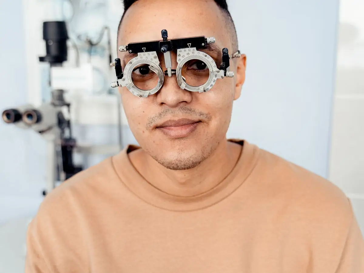 A smiling man wearing a trial frame during a sight test