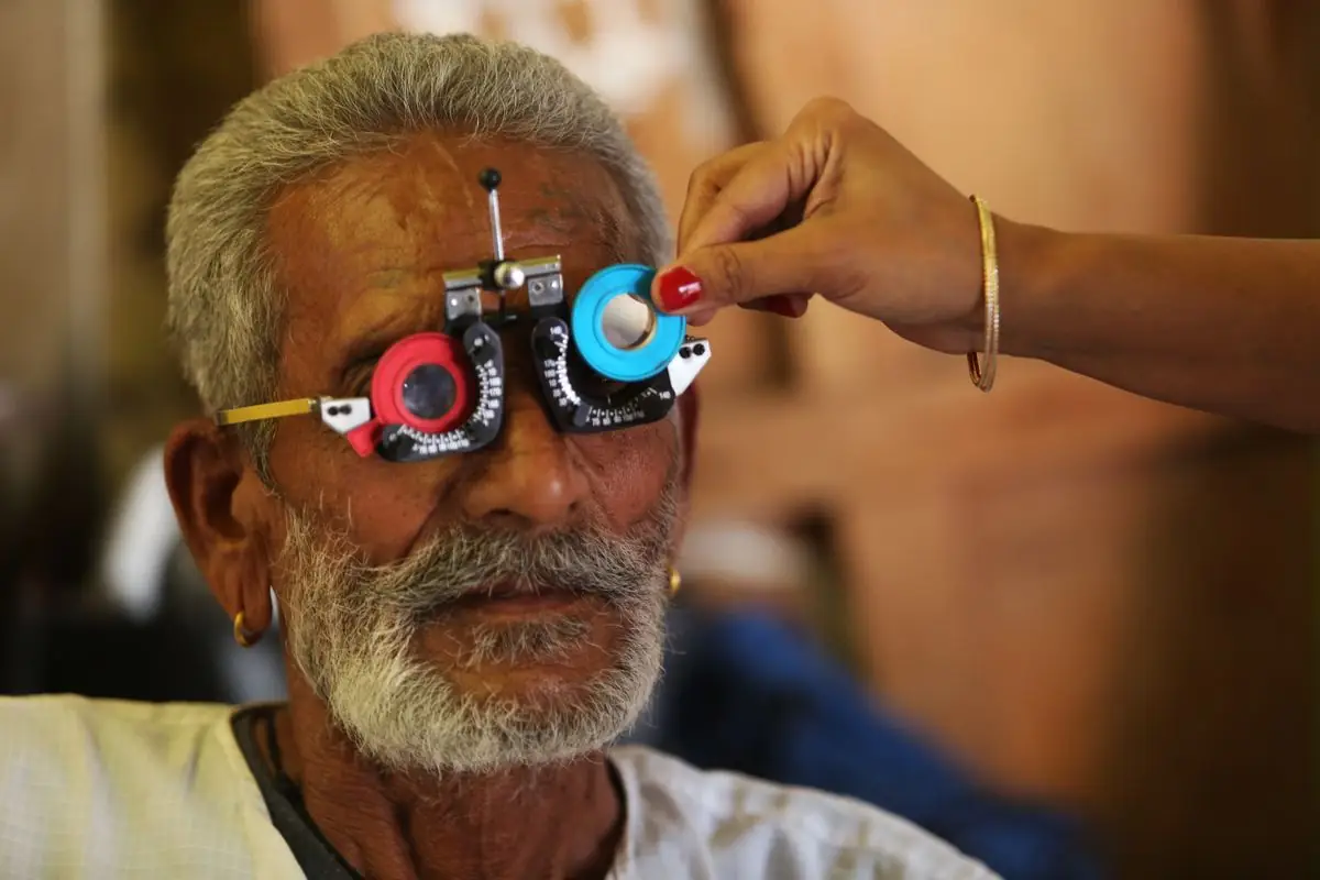 An older man having his sight tested with trial lenses